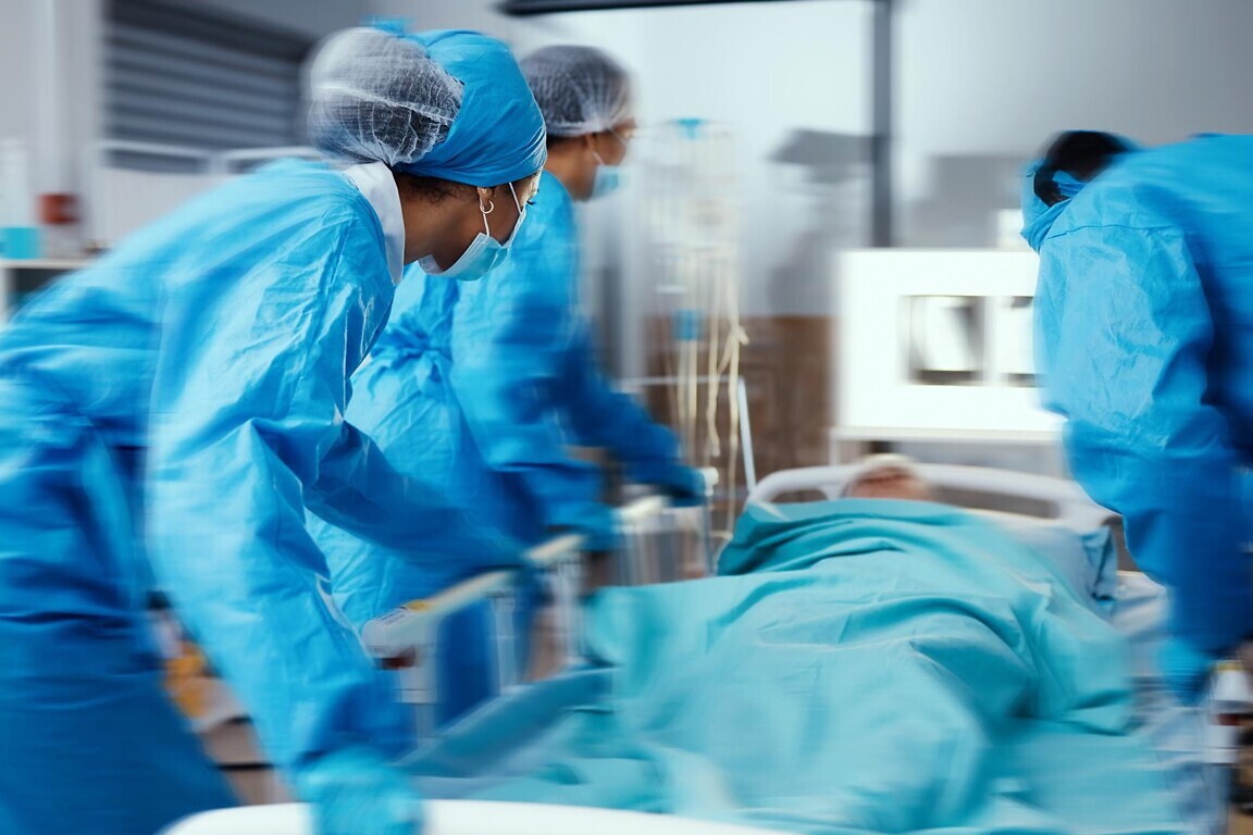 Women, man and hospital bed in motion blur of emergency surgery, healthcare wellness or risk condition operation. Doctors, nurses and medical workers with patient in busy er, theatre room or teamwork.