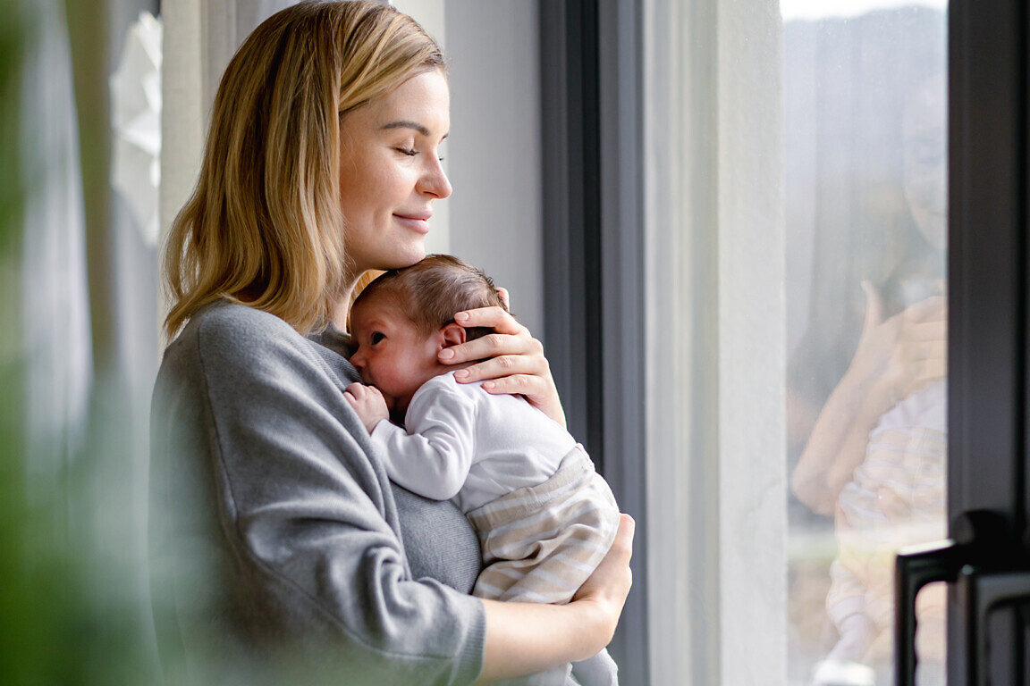 Loving mother hugs her little baby at home