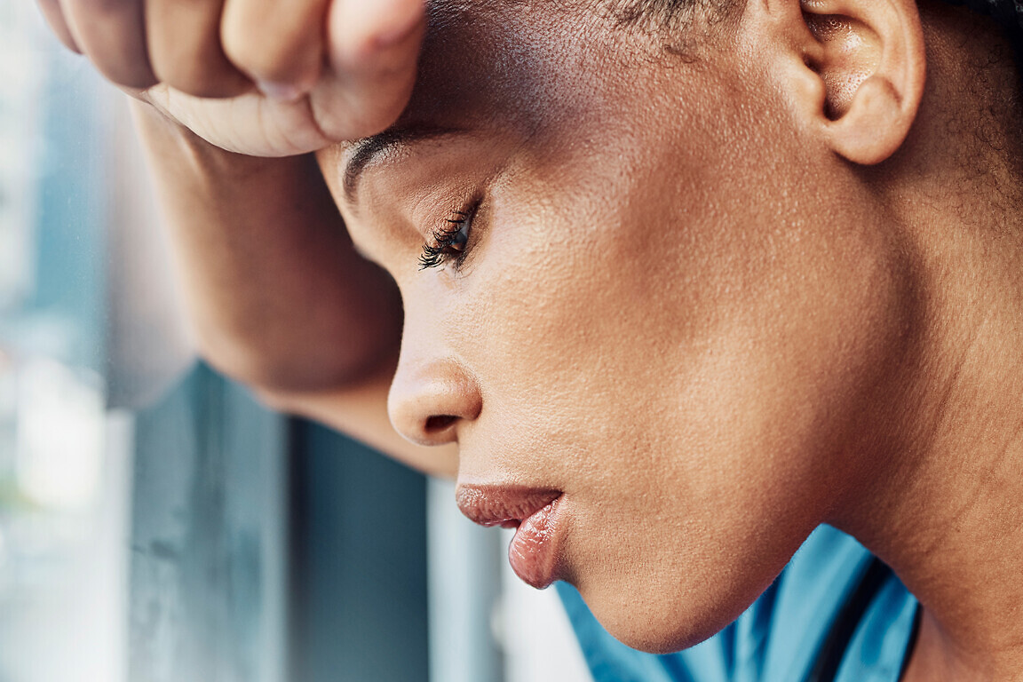 Doctor, black woman burnout and anxiety in hospital, workplace and tired in healthcare job, stress or headache. Nurse, sad and exhausted in medical clinic or depression in health hospital by window