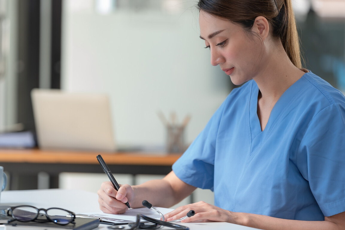 Female doctor writing a letter of referral for a patient.