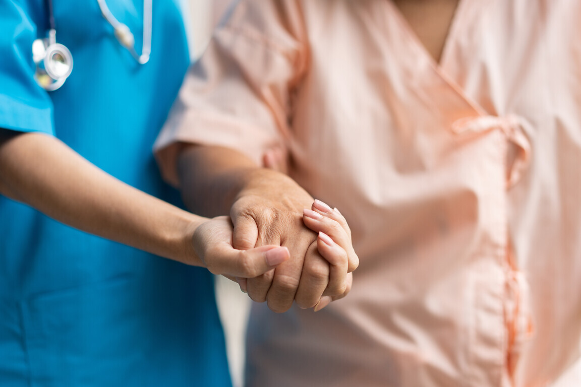 Caregiver holding patient's hand