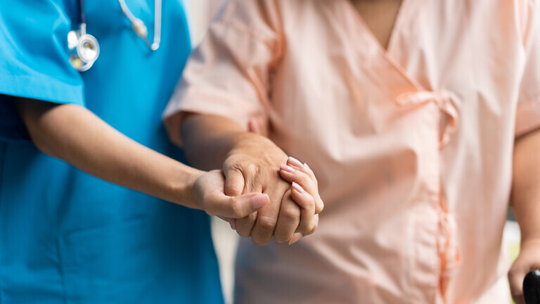 Caregiver holding patient's hand