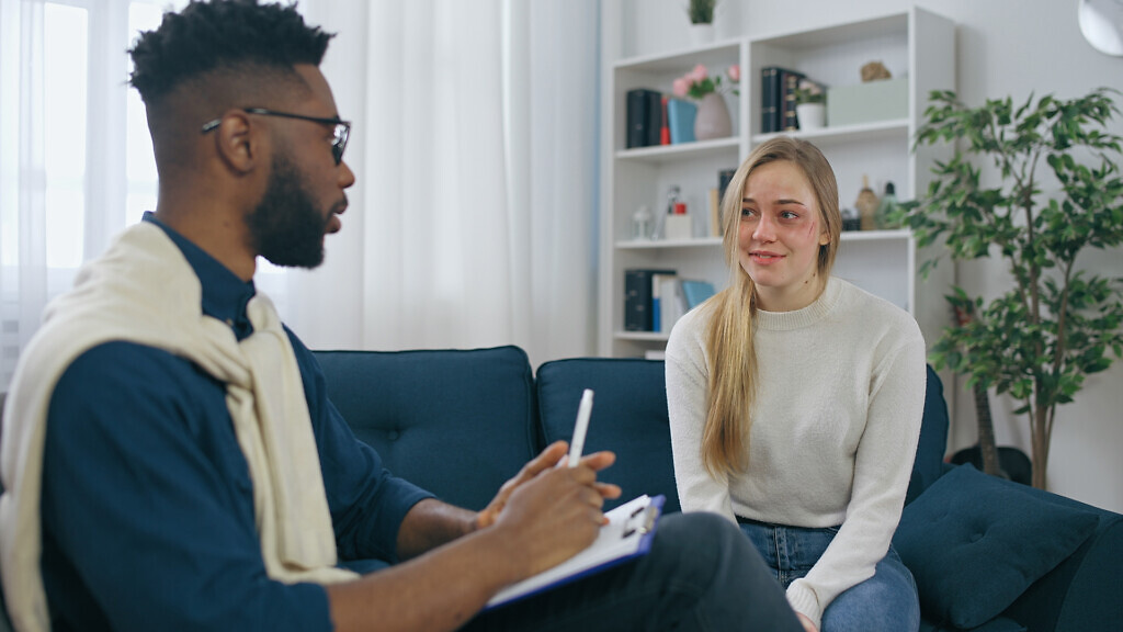 Male psychiatrist encouraging harassed woman