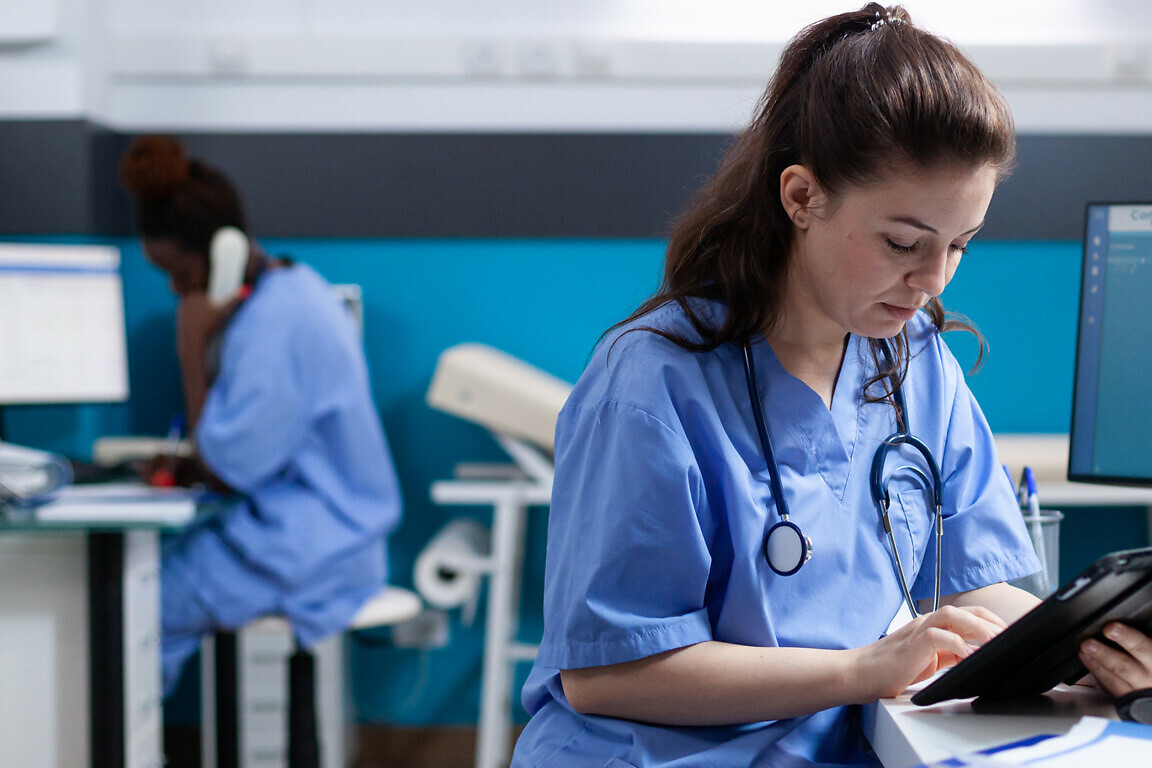 Nurse checking appointments on tablet
