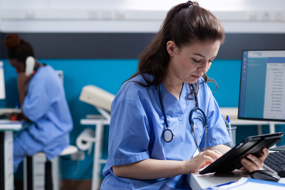 Nurse checking appointments on tablet