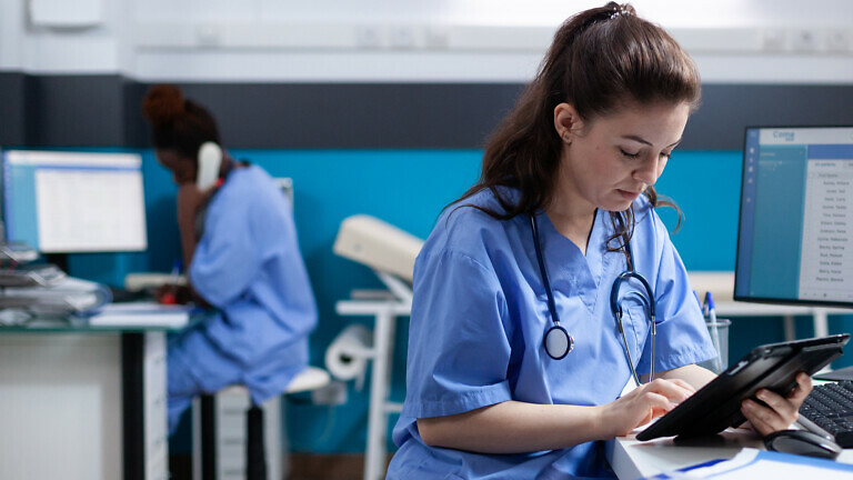 Nurse checking appointments on tablet