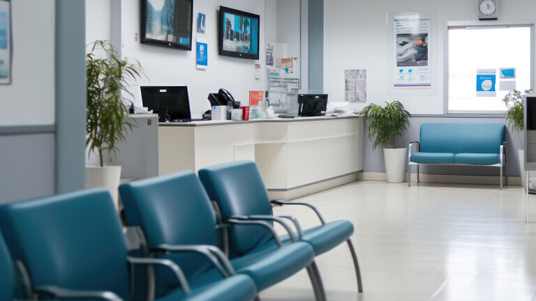 Waiting room with reception counter at medical facility.