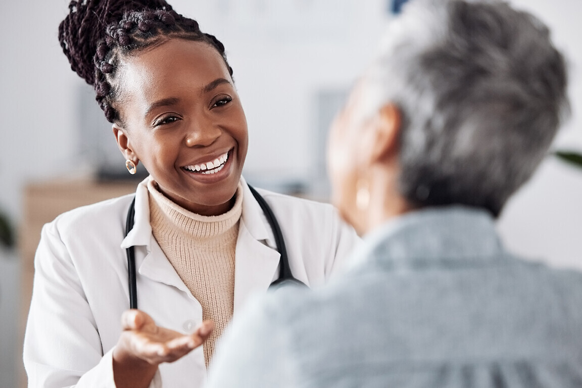 Doctor consulting a patient in meeting in hospital for healthcare feedback or support. Happy, medical or nurse with a mature person talking or speaking of test results or advice.