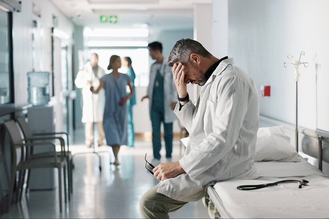 Depression, grief or fail with a mature doctor in a hospital looking unhappy for healthcare or medical. Stress, mistake or loss with a sad man medicine professional in a professional medicare clinic