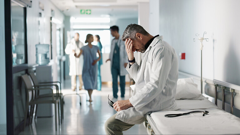 Depression, grief or fail with a mature doctor in a hospital looking unhappy for healthcare or medical. Stress, mistake or loss with a sad man medicine professional in a professional medicare clinic