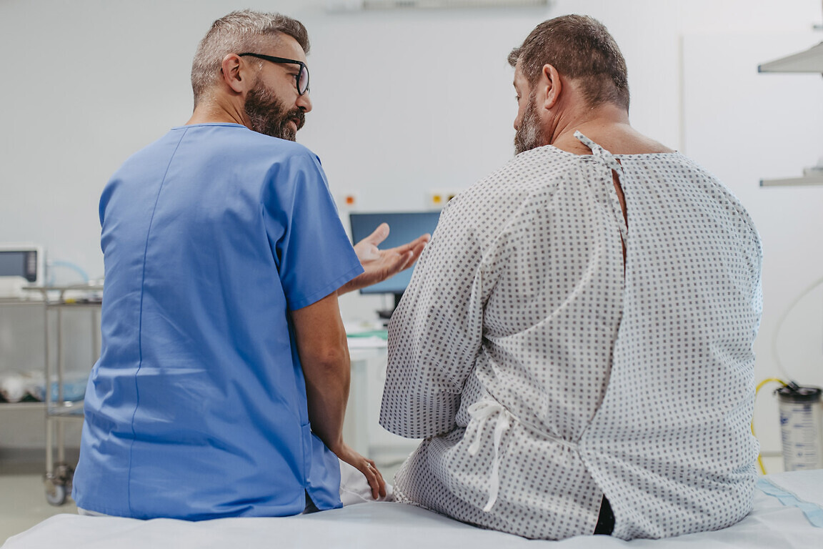 Supportive doctor soothing a worried overweight patient, discussing test result in emergency room. Illnesses and diseases in middle-aged men's health. Compassionate physician supporting stressed patient. Concept of health risks of overwight and obesity.