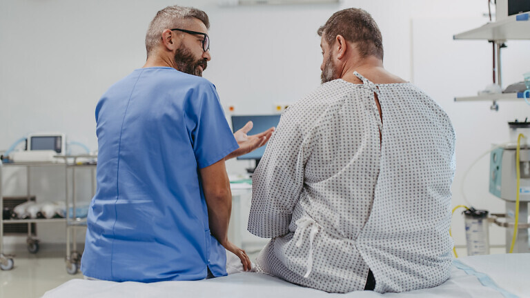 Supportive doctor soothing a worried overweight patient, discussing test result in emergency room. Illnesses and diseases in middle-aged men's health. Compassionate physician supporting stressed patient. Concept of health risks of overwight and obesity.