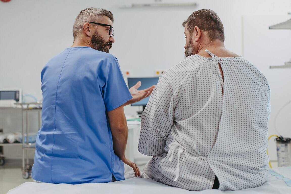 Supportive doctor soothing a worried overweight patient, discussing test result in emergency room. Illnesses and diseases in middle-aged men's health. Compassionate physician supporting stressed patient. Concept of health risks of overwight and obesity.