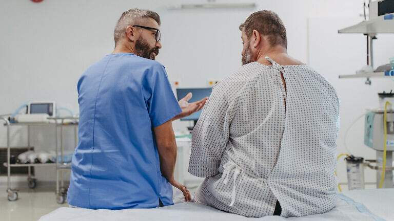 Supportive doctor soothing a worried overweight patient, discussing test result in emergency room. Illnesses and diseases in middle-aged men's health. Compassionate physician supporting stressed patient. Concept of health risks of overwight and obesity.