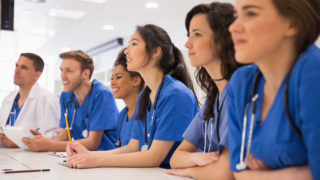 Medical students listening sitting at desk