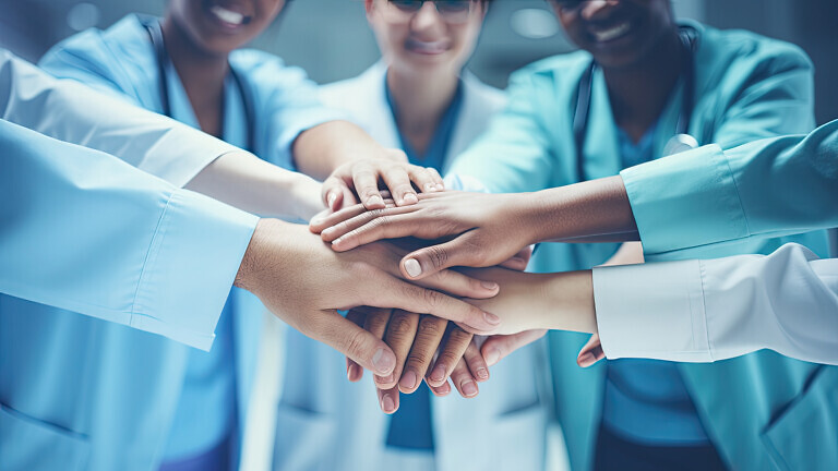 A bunch of medical staff put their hands together