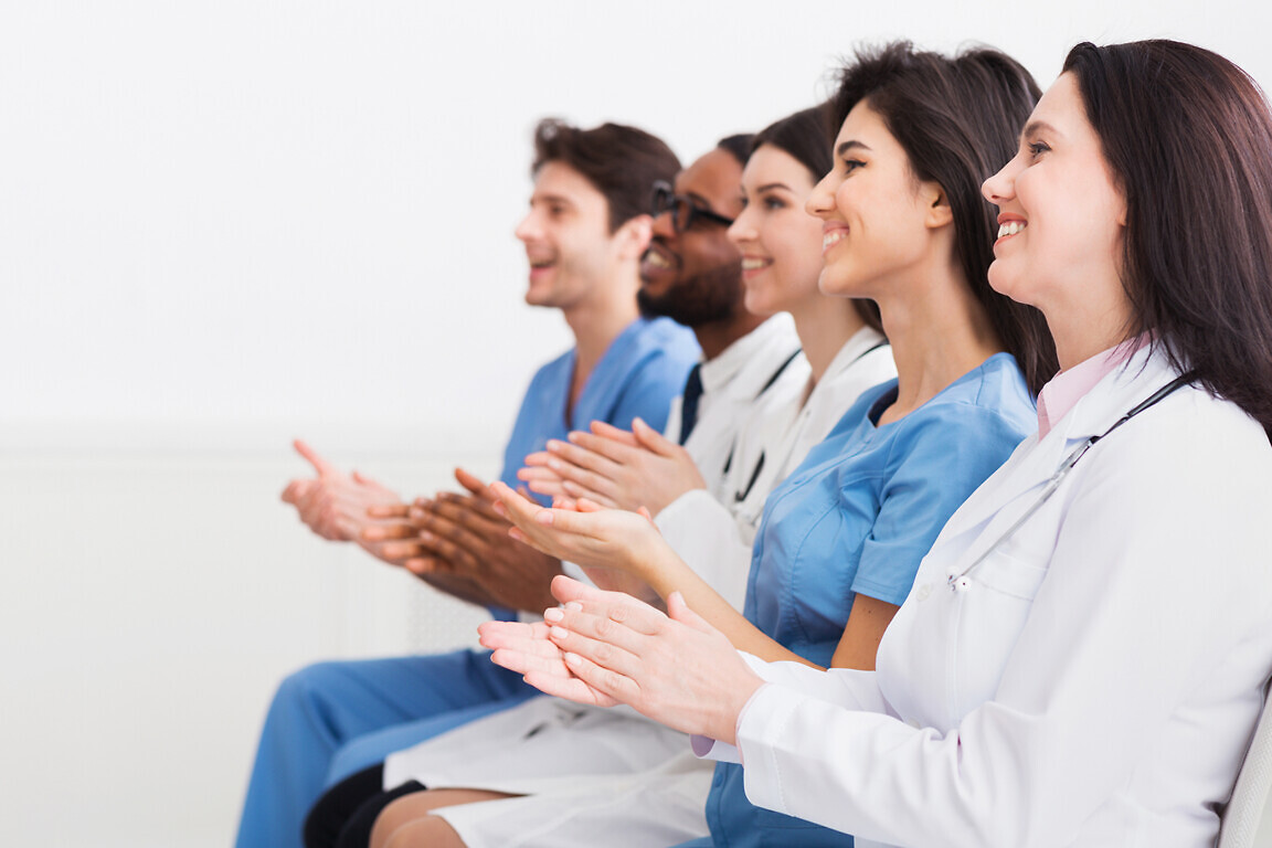 General Practitioners Applauding To Successful Lecturer In Room