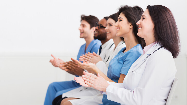 General Practitioners Applauding To Successful Lecturer In Room