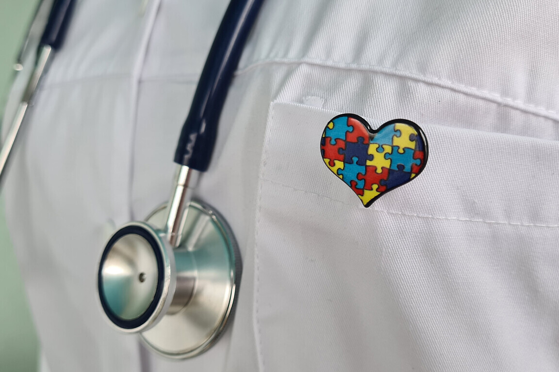 A Doctor Wearing a Stethoscope and a Puzzle Piece Heart Pin