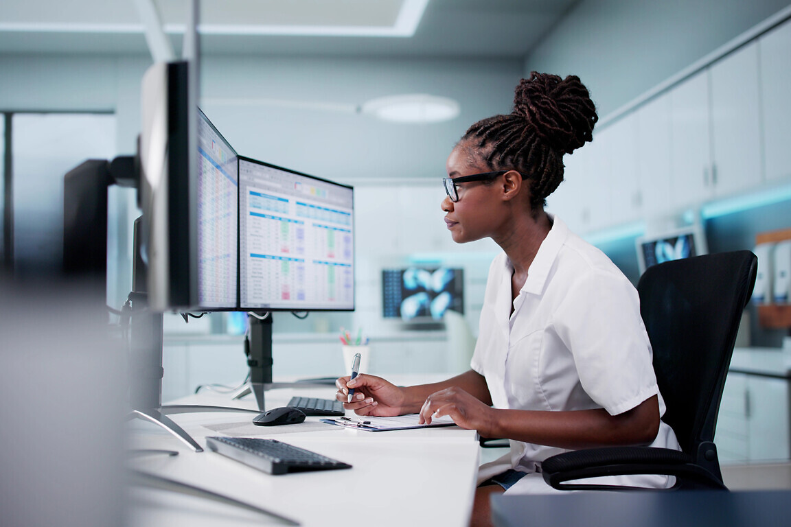 Hospital Doctor Using Spreadsheet For Billing Codes On Desktop