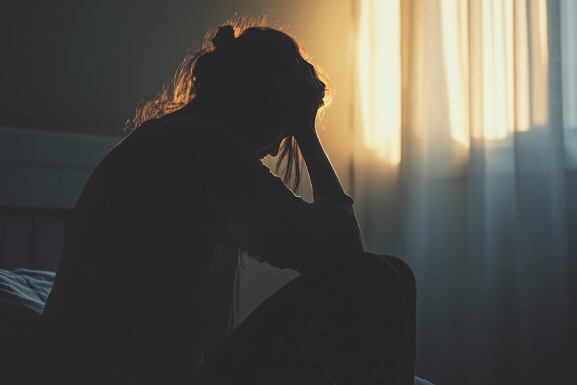 A depressed woman sitting in the dark room