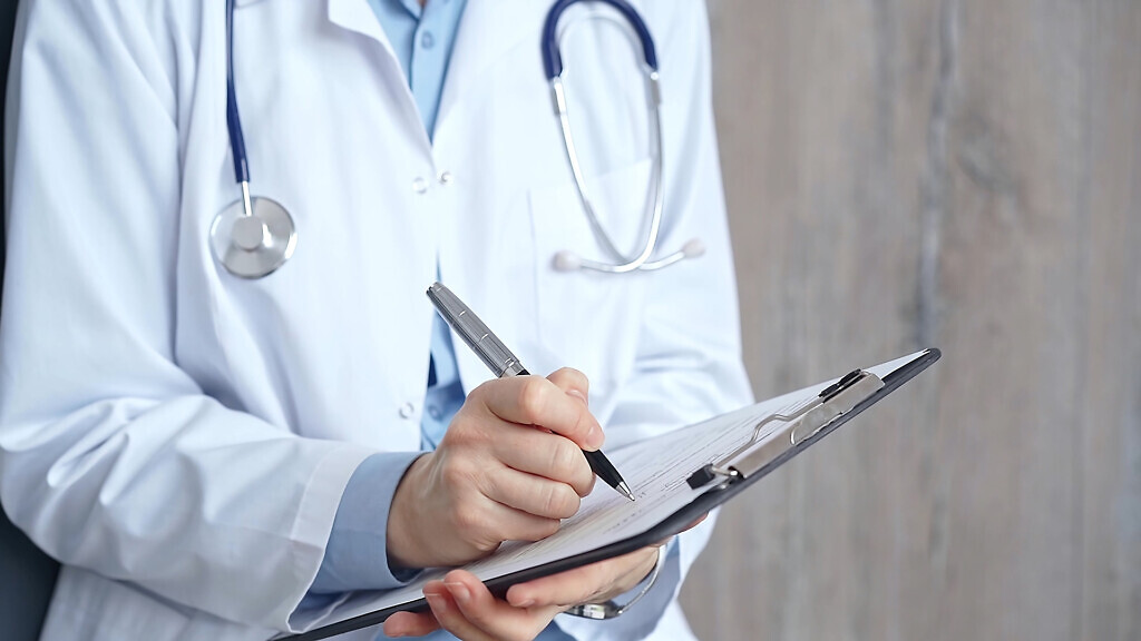 Healthcare professional doctor writing medical records on a clipboard. Female unrecognizable physician at work. Medicine and pharmacy.