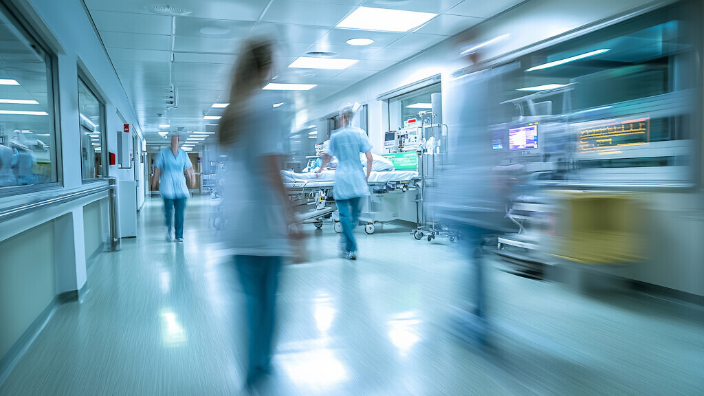 Busy hospital corridor with medical staff in motion.