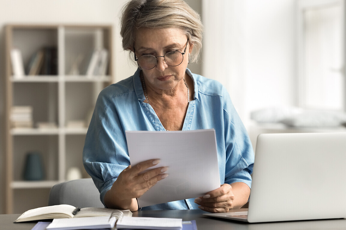 Older woman with serious expression reading document