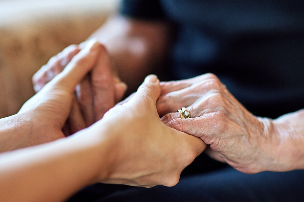 Senior, hope or people holding hands for praying, support or comfort for care, trust or worship. Closeup, faith or mourning with widow or kindness for help, grief or peace for loss or healing in home.